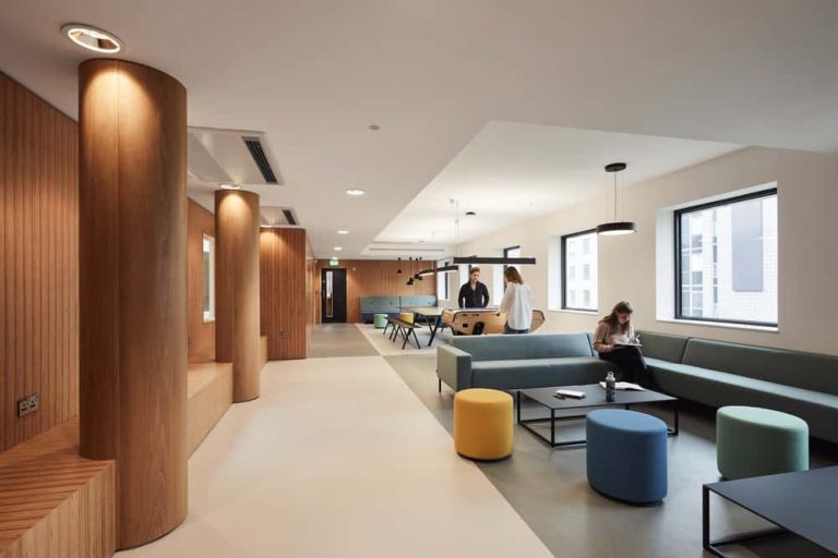 Students working in a large open plan communal space in the Duke Street Riverside accommodation at Norwich University of the Arts