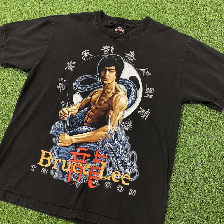 A black Bruce Lee t-shirt laid out on the floor with an illustration of the martial arts actor and a blue dragon