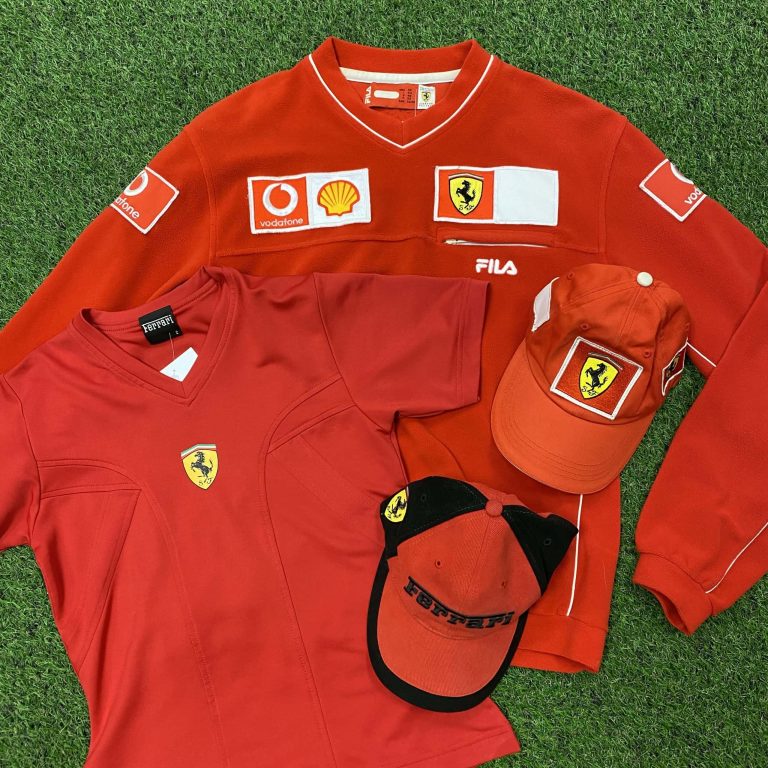 Ferrari jumper, t-shirt and two hats laid out on the floor