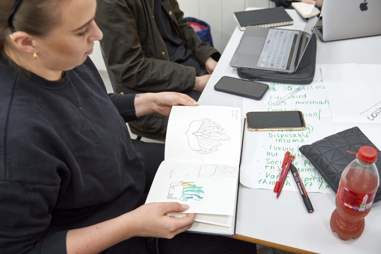 A female student looking through her sketchbook.