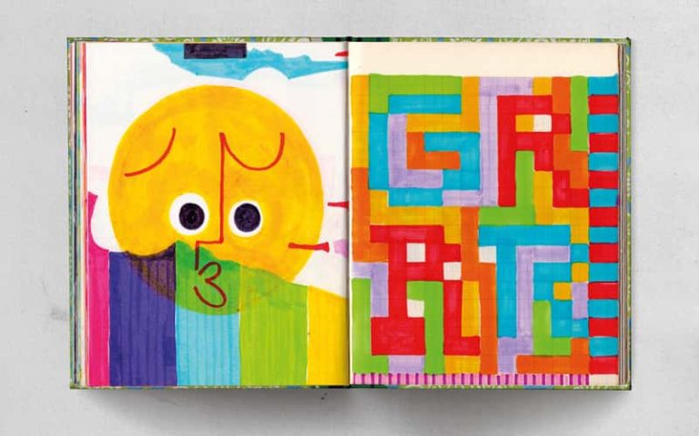 A handmade book open flat to show two pages. On the left is a colourful illustration of a face drawn from a single red line, on top of rainbow stripes. Above the stripes and directly behind the face is a sun-yellow circle. On the right hand page, multicoloured blocks laid in a glitch-style pattern spell out GRRR