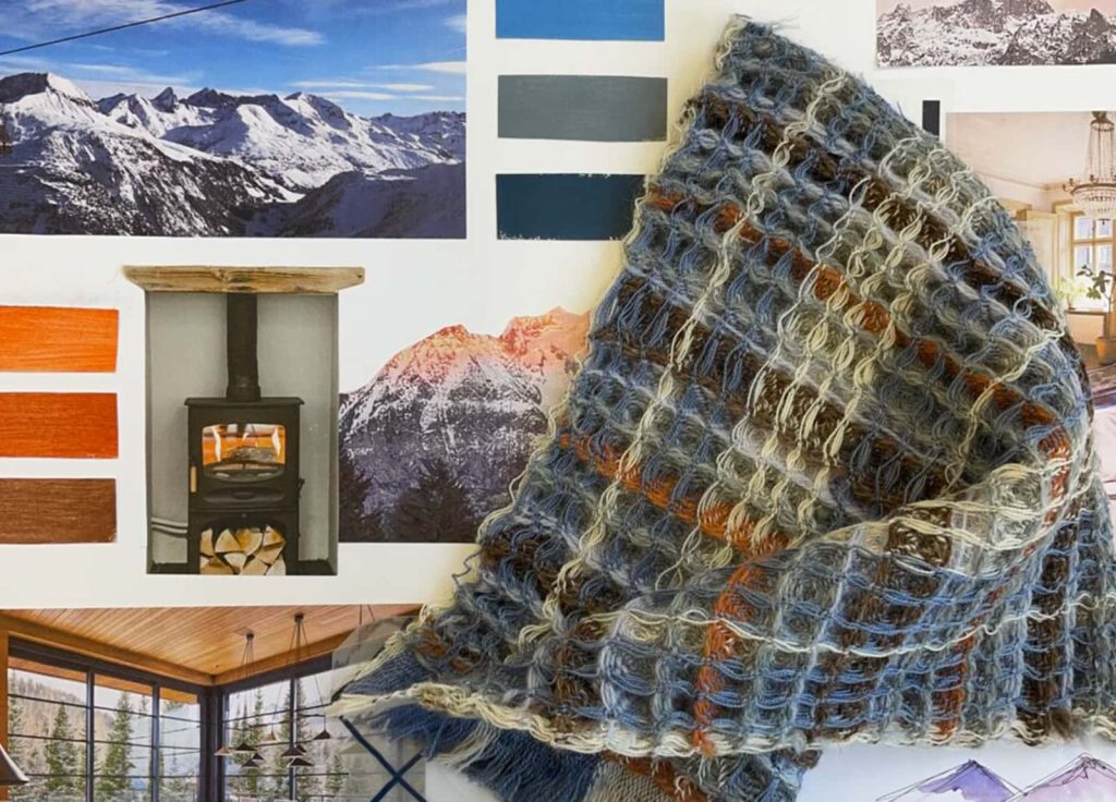 A textile sample of a heavy blue, brown and white weave. Behind are several concept images of mountains and alpine lodges, and some colour swatches.