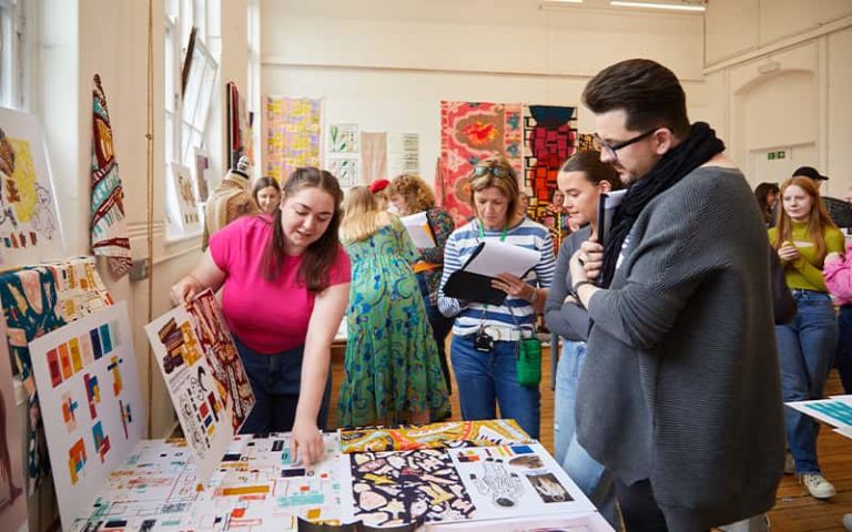 A BA (Hons) Textile Design student talking to a group of judges at the Textile Design Industry Awards