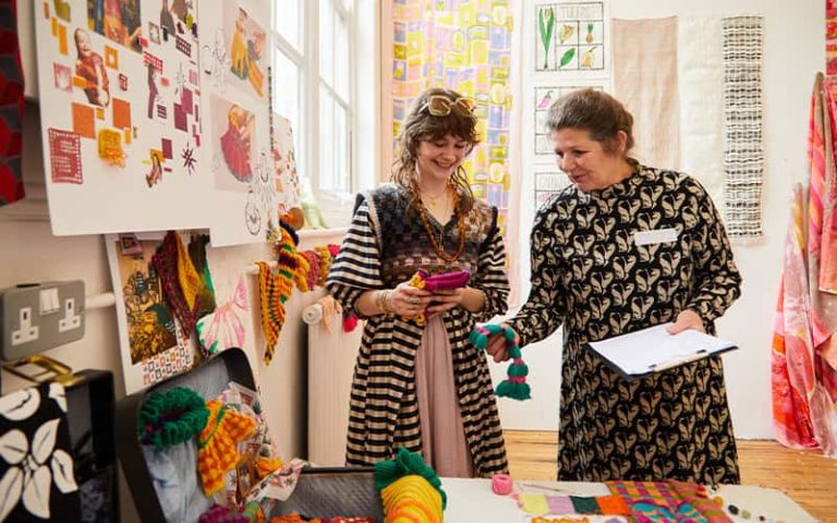 A BA (Hons) Textile Design student talking to a judge at the Textile Design Industry Awards