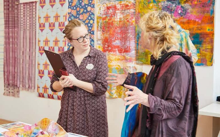 A BA (Hons) Textile Design student talking to a judge at the Textile Design Industry Awards