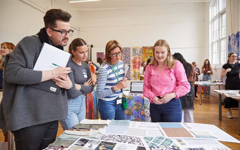 A BA (Hons) Textile Design student talking to a judge at the Textile Design Industry Awards