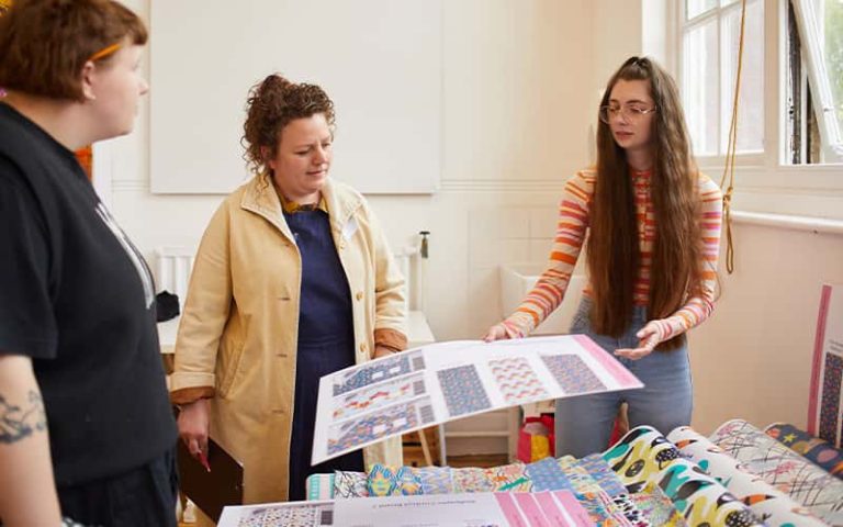 A BA (Hons) Textile Design student talking to a judge at the Textile Design Industry Awards