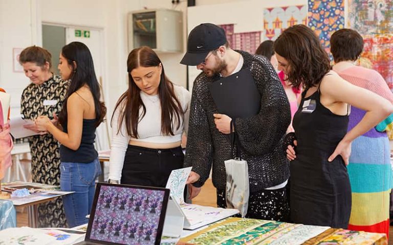 A BA (Hons) Textile Design student talking to a judge at the Textile Design Industry Awards