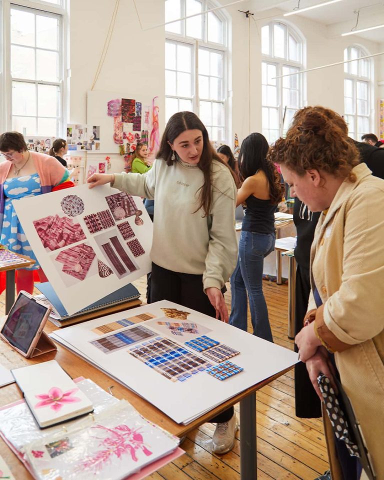 A BA (Hons) Textile Design student talking to a judge at the Textile Design Industry Awards