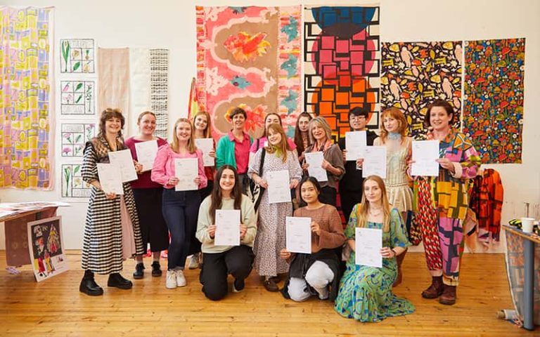 A photo of BA (Hons) Textile students holding their awards in a large group photo