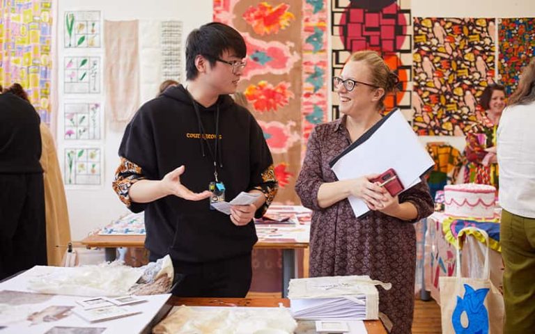 A BA (Hons) Textile Design student talking to a judge at the Textile Design Industry Awards