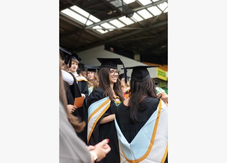 A photo of a female graduate smiling at Graduation 2023.