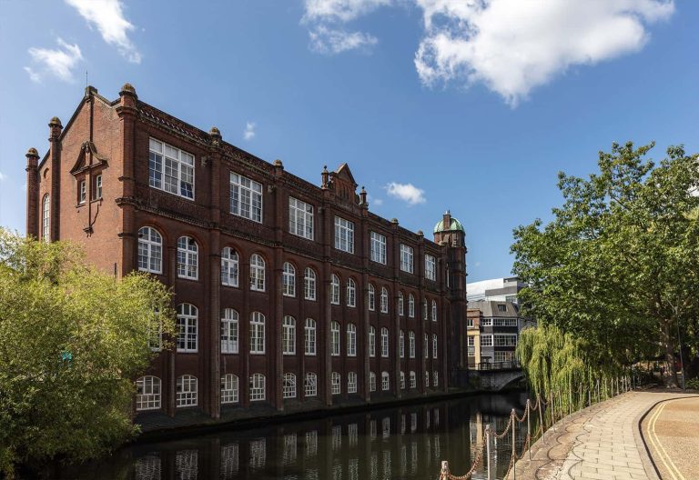 A photo of St. Georges building and the River Wensum on a summers day.