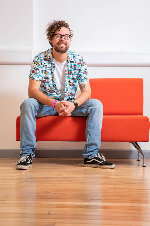 Technician Rich Wood sitting on an orange sofa