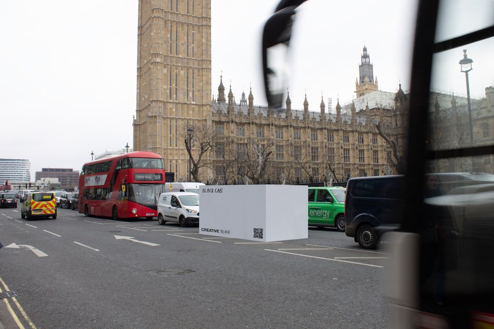 A photo of a white box sat in the middle of a busy London road.