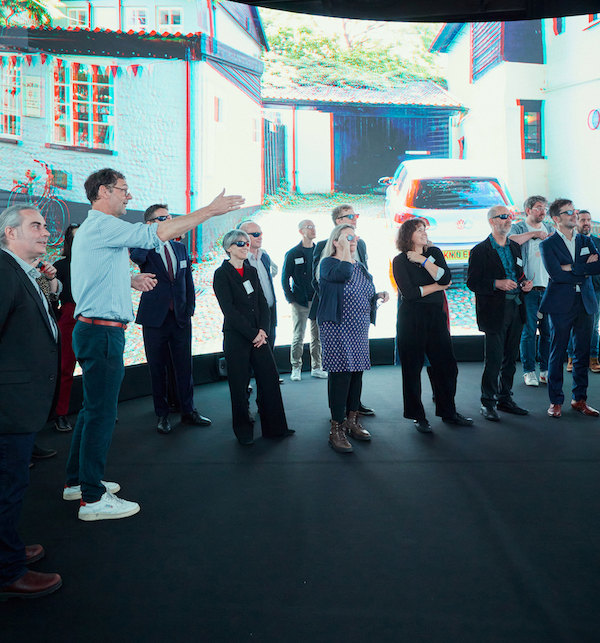 An audience viewing a 3D image of Elm Hill in Norwich on a 360 LED screen.