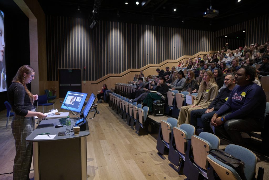 A photo from the Digital Fashion Symposium at Duke Street Riverside. The photo is of Emma Thompson presenting to a large group of people in the lecture theatre.