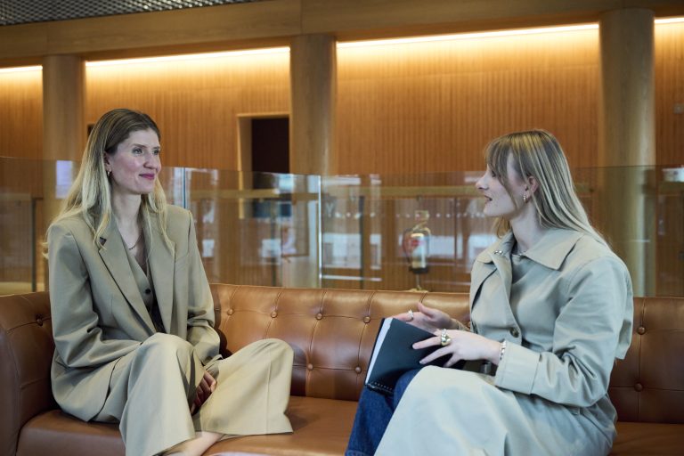 A photo of Lauren Ingram, founder of Women of Web3, sat down on a sofa talking to a student.