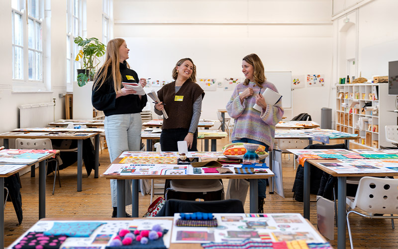 Habitat designers Tasha Warren, Charlotte Robinson and Louise Rynehart laughing together and assessing students work.