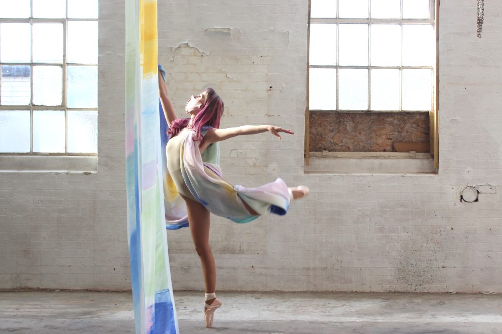 A photo of Brooke Savino's BA (Hons) Fine Art work. The image is of a female holding a dance pose parallel to a large and draping piece of material.