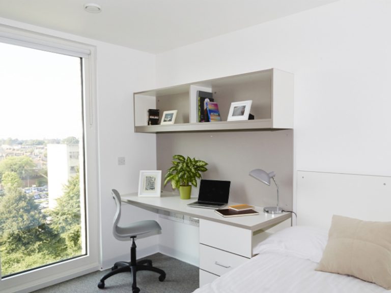 Light and airy bedroom with desk and bed in All Saints Green with a tall window