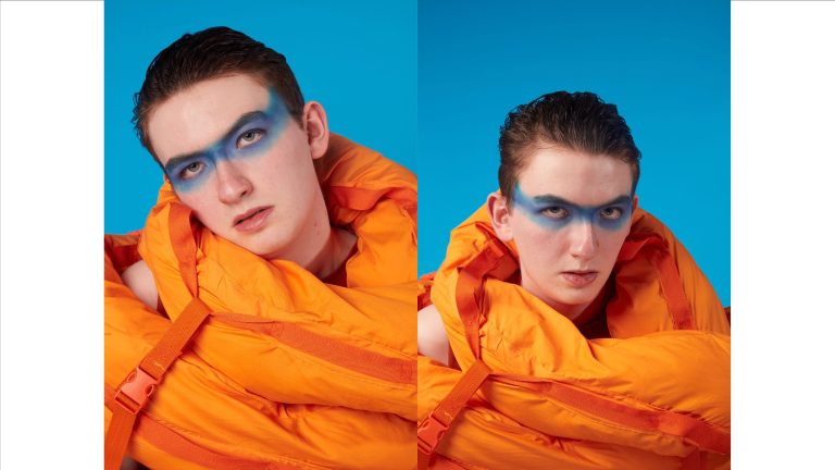 Two photographs by May Gauntlett. Head and shoulders of a model wearing a bright orange outfit. They have a strip of bright blue facepaint across their eyes and are in front of a blue background.