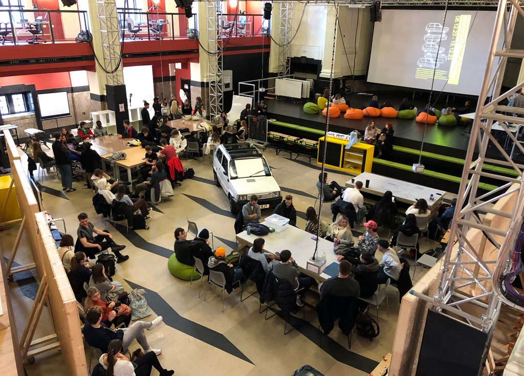 The project studio at Norwich University of the Arts where a Fiat Panda is surrounded by 1:1 scale cardboard cutout replicas hanging from the ceiling around it