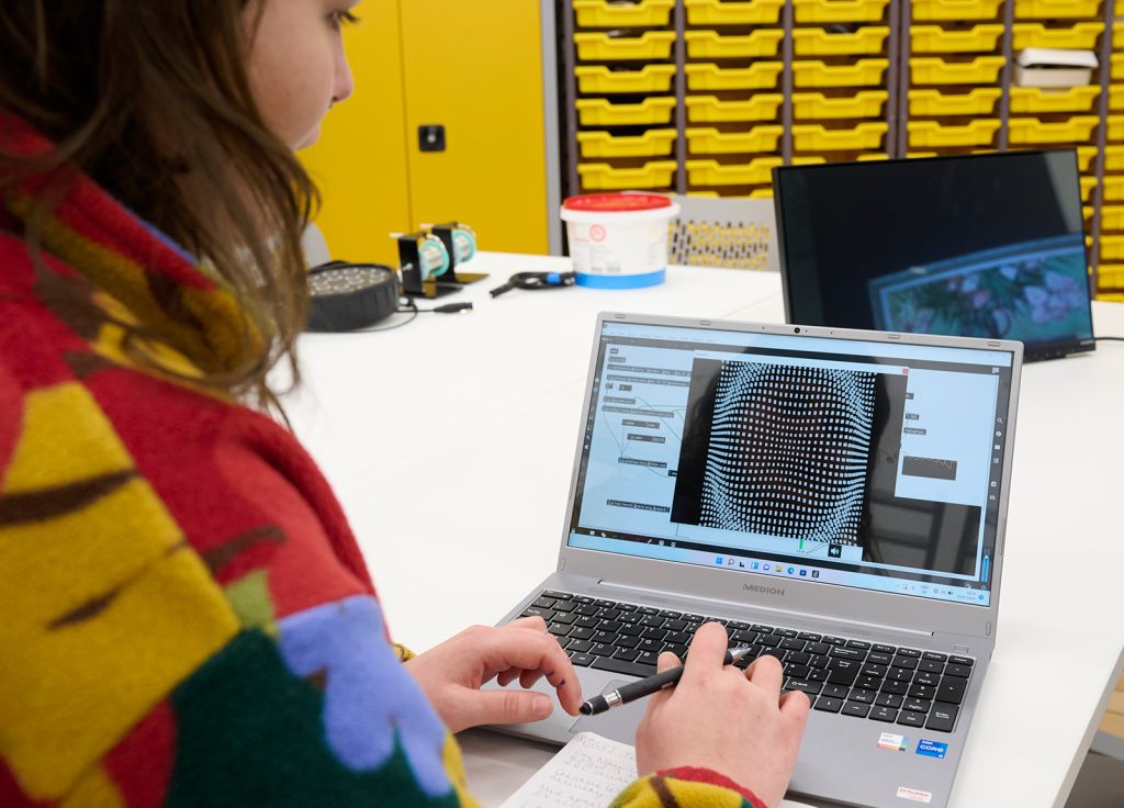 A student working on a laptop in the Creative Tech Lab at Norwich University of the Arts