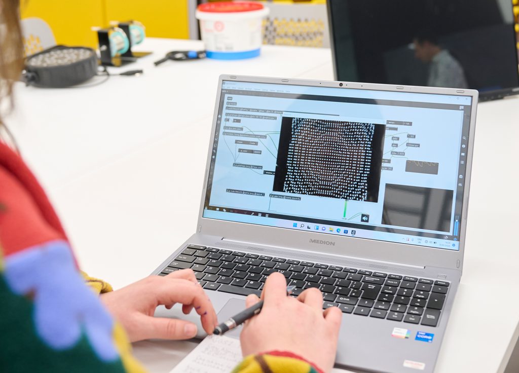 A student working on a laptop in the Creative Tech Lab at Norwich University of the Arts