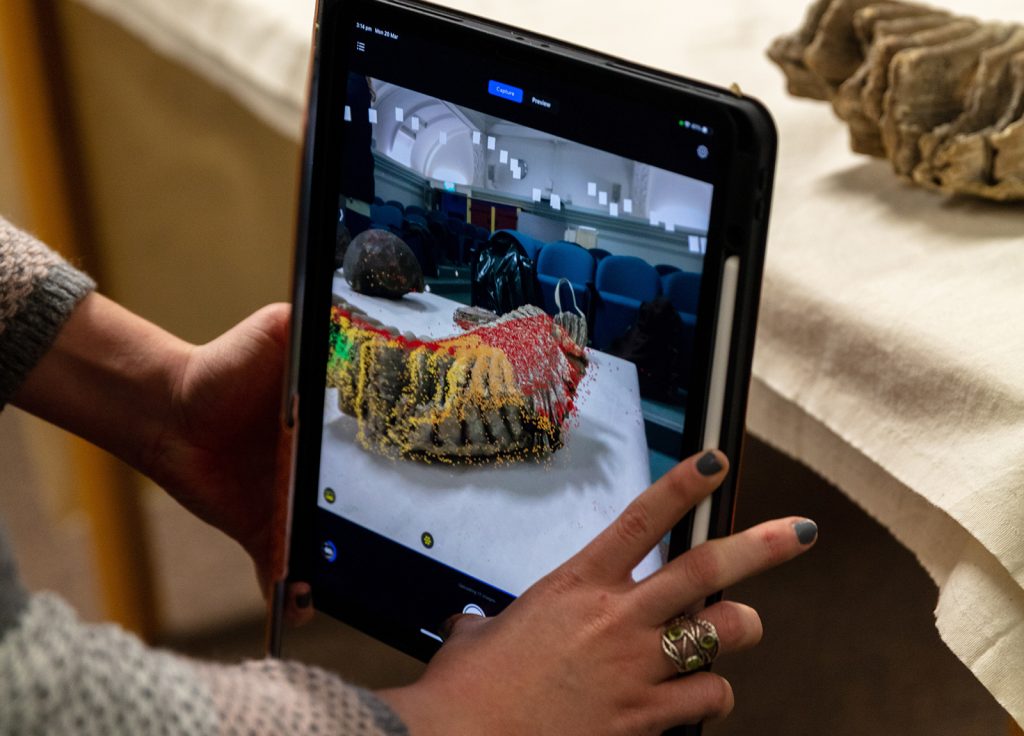 Close up of a person 3D scanning a bone with an ipad.