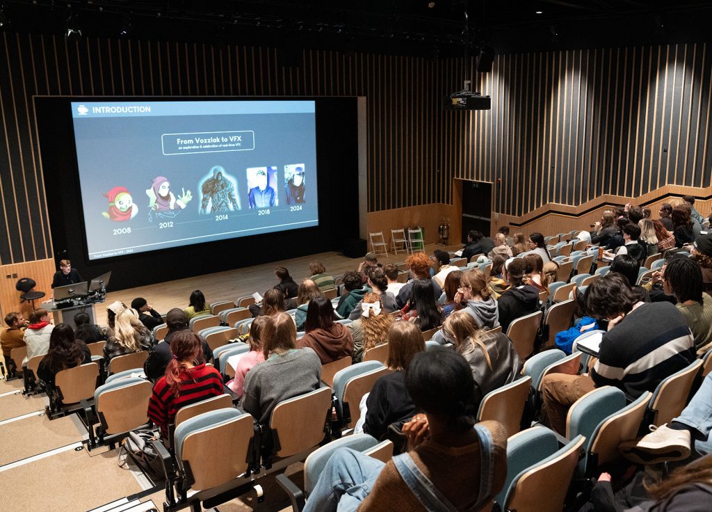 Audience attending a lecture in an auditorium with a presentation slide about visual effects.