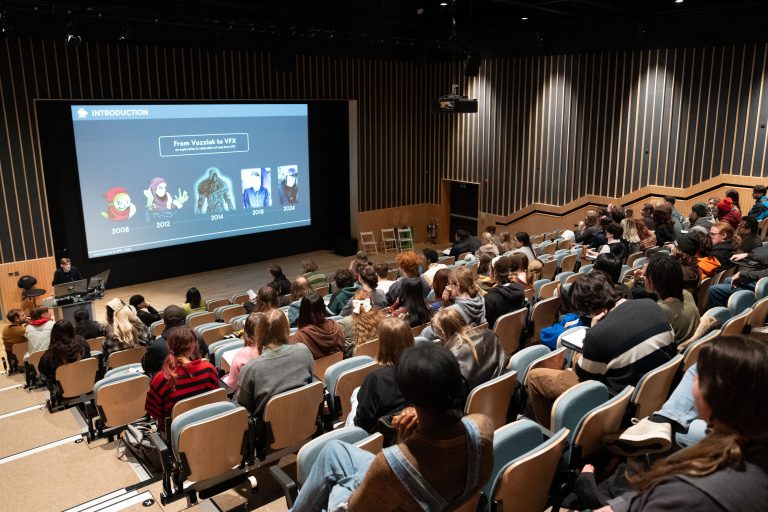 Audience attending a lecture in an auditorium with a presentation slide about visual effects.