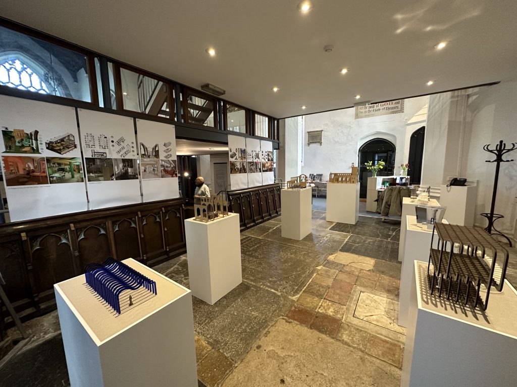 A photograph of St. Martin's Church. The space has been used to host an exhibition of BA (Hons) Interior design students work. Various models of the students work sit on stands throughout the room.