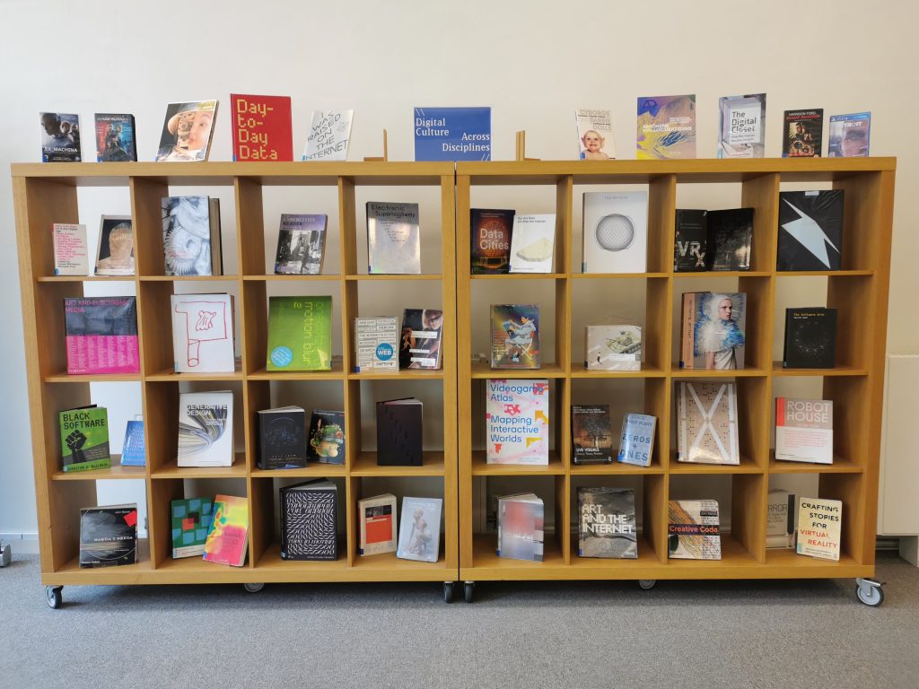 A cubed shelf system with multi coloured books on it.