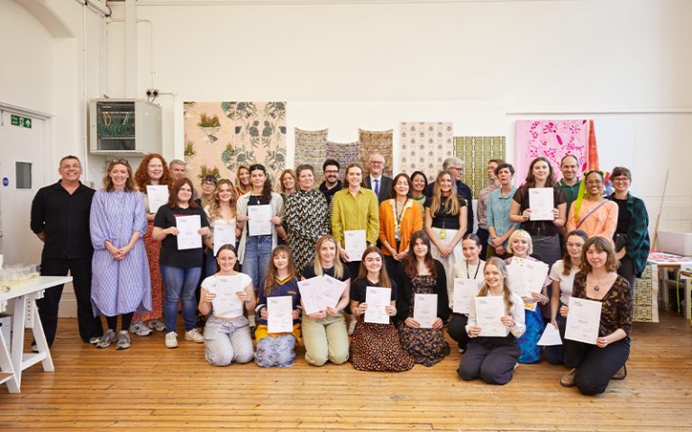 A photo from the Textile Design Industry Awards 2024. The image is of the students, staff and judging panel in a group and smiling at the camera.