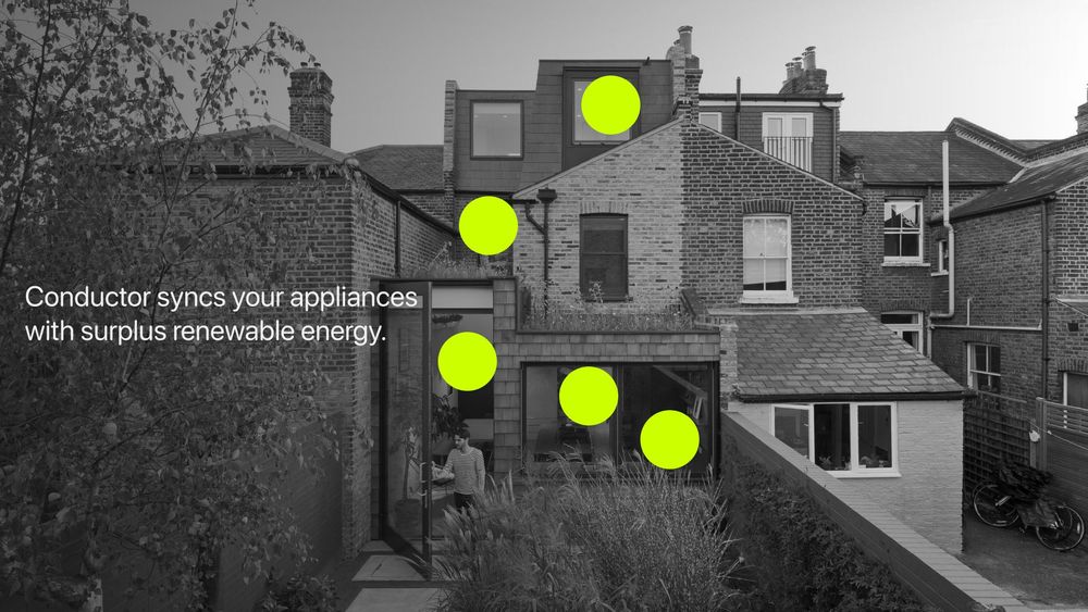 A black and white photograph of the back of a brick house with an extension. Bright green dots are placed on various points of the house. The text reads: "Conductor syncs your appliances with surplus renewable energy.