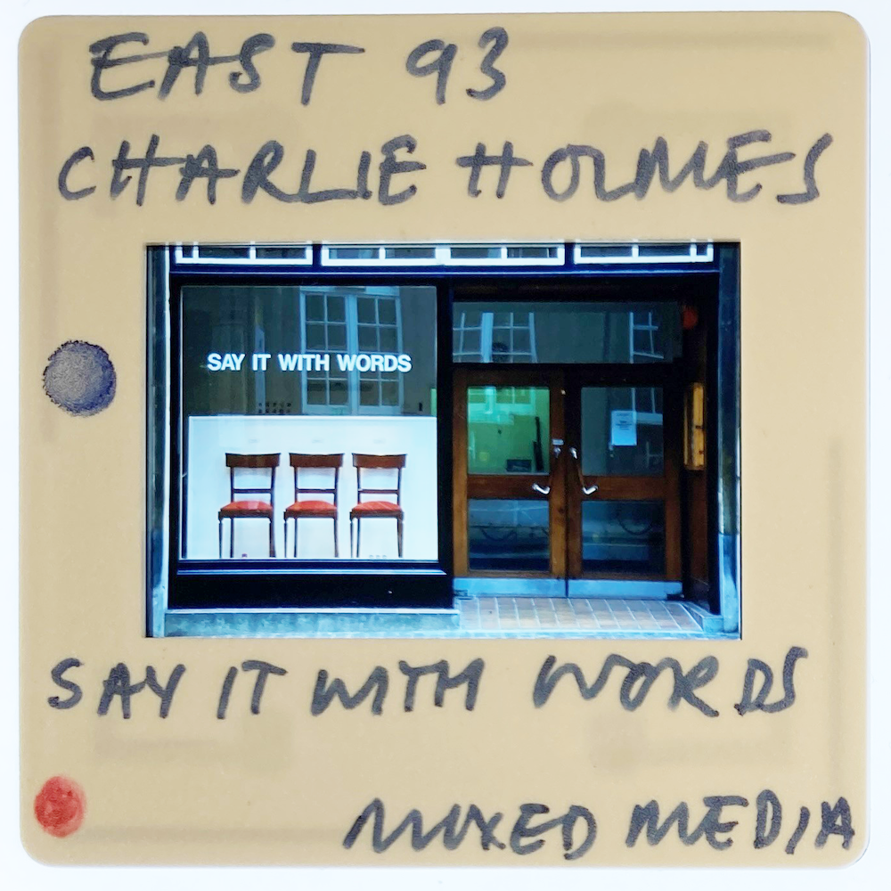 A slide labelled "East 93 Charlie Holmes" and "Say It With Words Mixed Media" features a photo of the Norwich Gallery frontage with three chairs and a sign saying "Say It With Words".