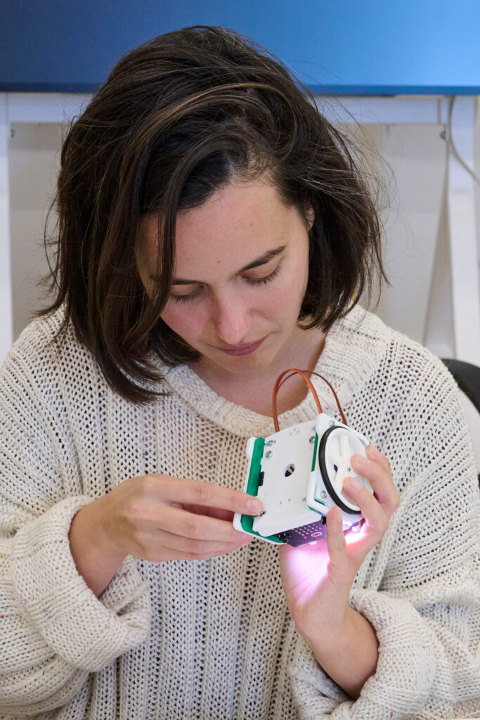 A photo of a student tinkering with a mini BBC micro:bit, a pocket-sized codeable computer