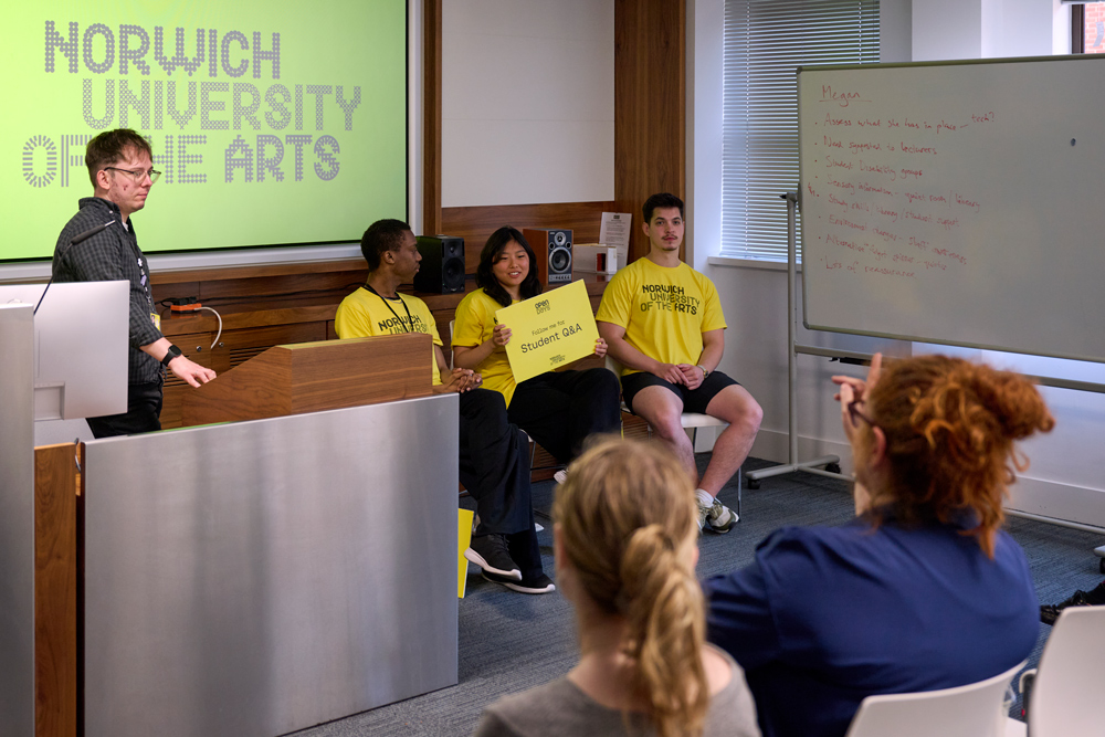 A photo of three students and one staff member at Norwich University of the Arts hosting a panel session for questions and answers, at one of the University's open days