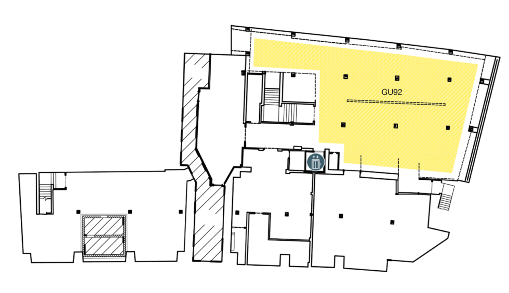 A floor plan highlighting a large room labeled "GU92" in yellow. Stairs, elevators, and a restroom are nearby. Other rooms and hallways are shown but not highlighted.