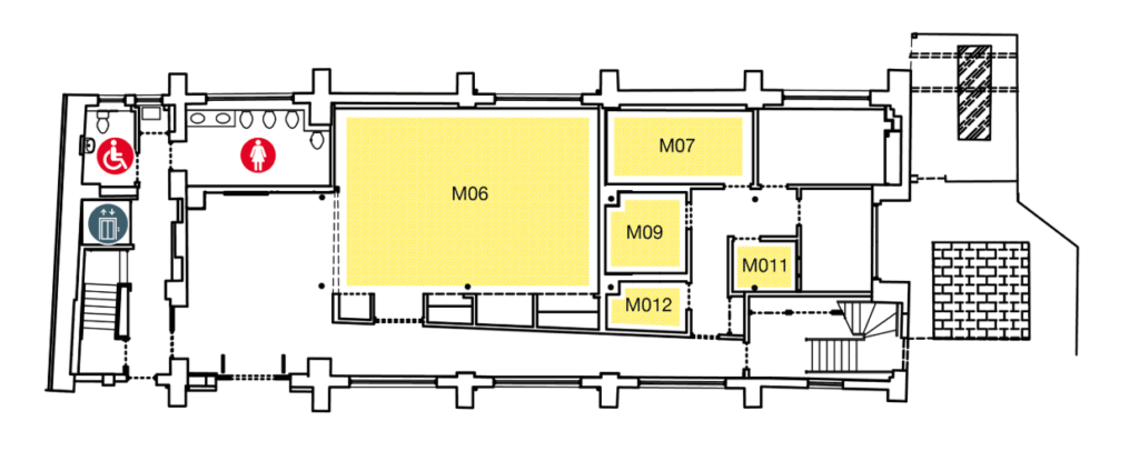 Floor plan showing rooms M06, M07, M09, M011, M012. Icons mark accessible and women’s restrooms and a trash bin near the entrance on the left. Stairs are at both ends of the hallway.
