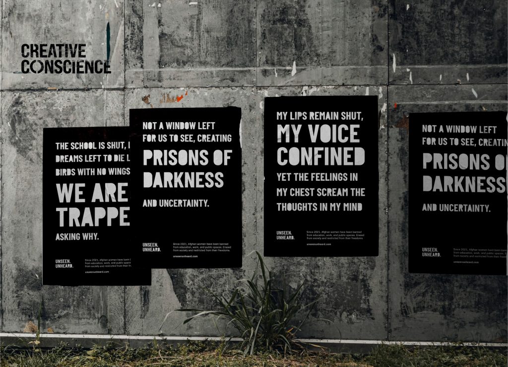 Four black posters with white text about confinement and uncertainty are pasted on a weathered concrete wall with the words "CREATIVE CONSCIENCE" above them. Grass grows along the base of the wall.