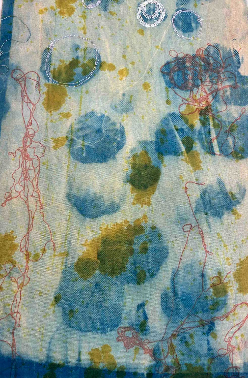 Blue circular shapes, greenish-yellow splatters, and loose red squiggly lines on a textured light background. The composition feels layered and organic.