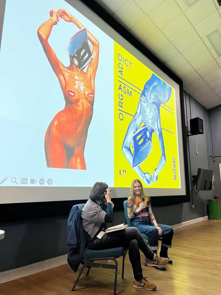 Two people sit and talk in front of a large screen displaying vibrant artwork of a nude figure with a helmet. The left image has a white background; the right image has a yellow background with blue text.