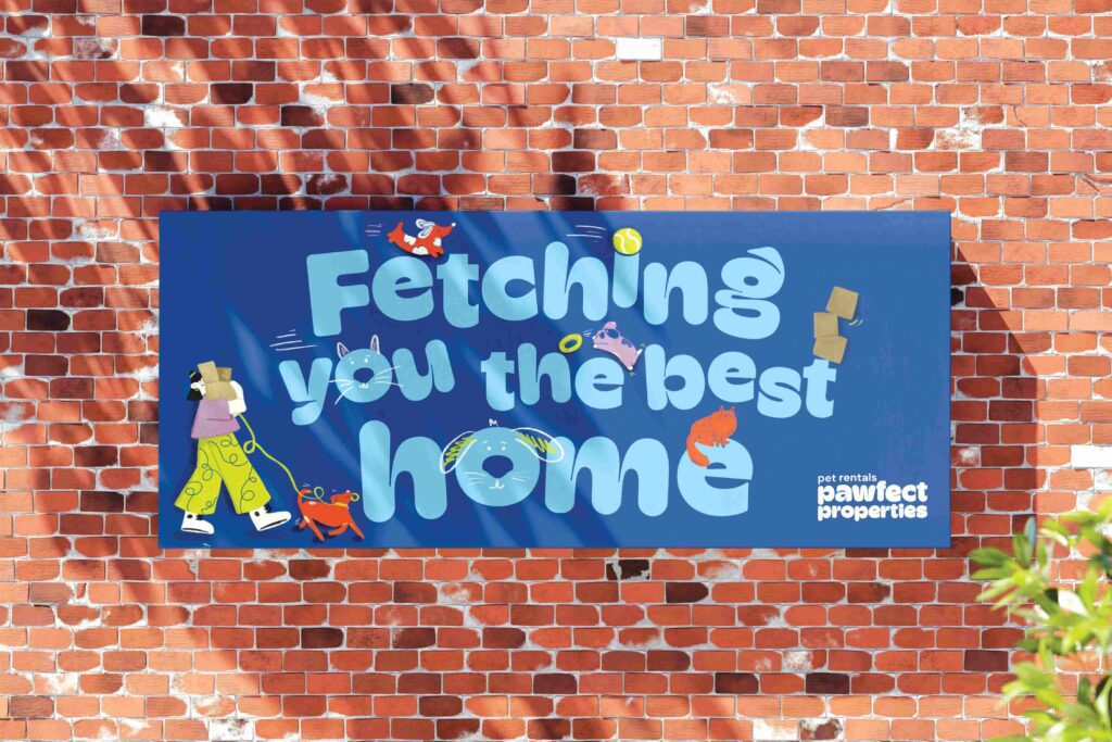 A colorful billboard on a brick wall reads “Fetching you the best home” with playful pet-themed graphics. A person walks a dog, and toys, a bone, and a cat decorate the text. Logo: “pet rentals pawfect properties.”.