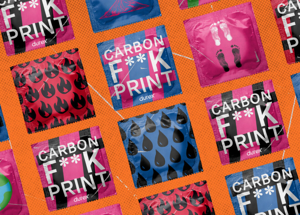 A flat lay of colorful Durex condom wrappers with various bold patterns, such as flames, water droplets, and footprints, plus some labeled "CARBON F**K PRINT," displayed on an orange textured background.