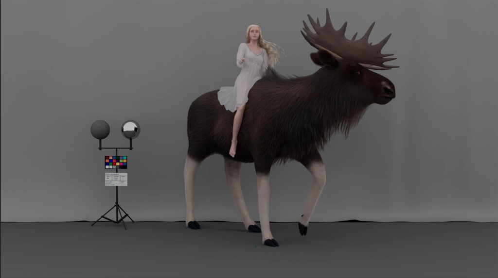 A woman in a white dress sits on a large moose in a studio setting with grey backdrop. To the left, a colour chart and two spherical objects are mounted on a tripod.