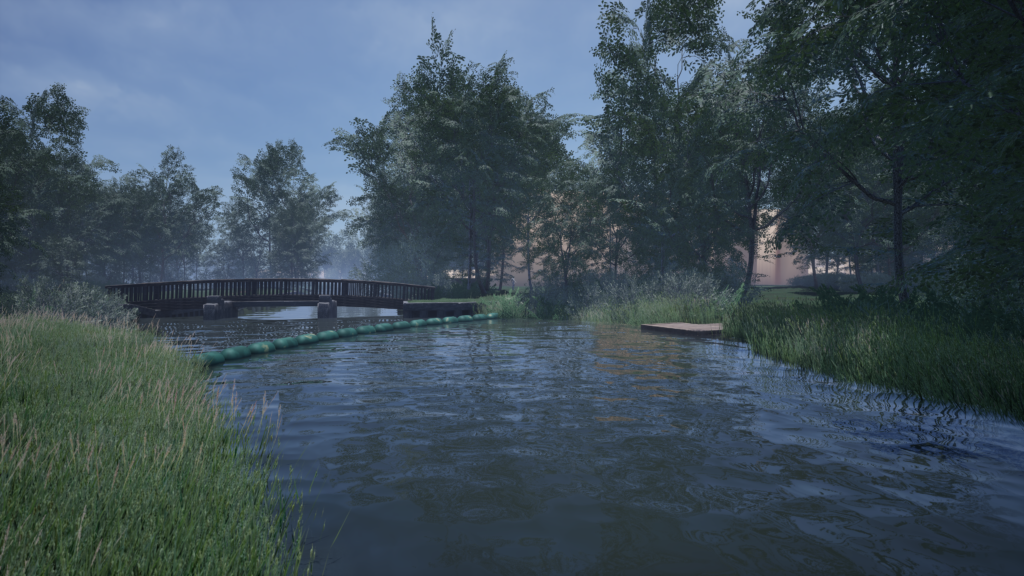 A calm river with green grass on both sides, a wooden footbridge crossing over it, floating barriers in the water, and tall trees under a blue sky with light clouds.