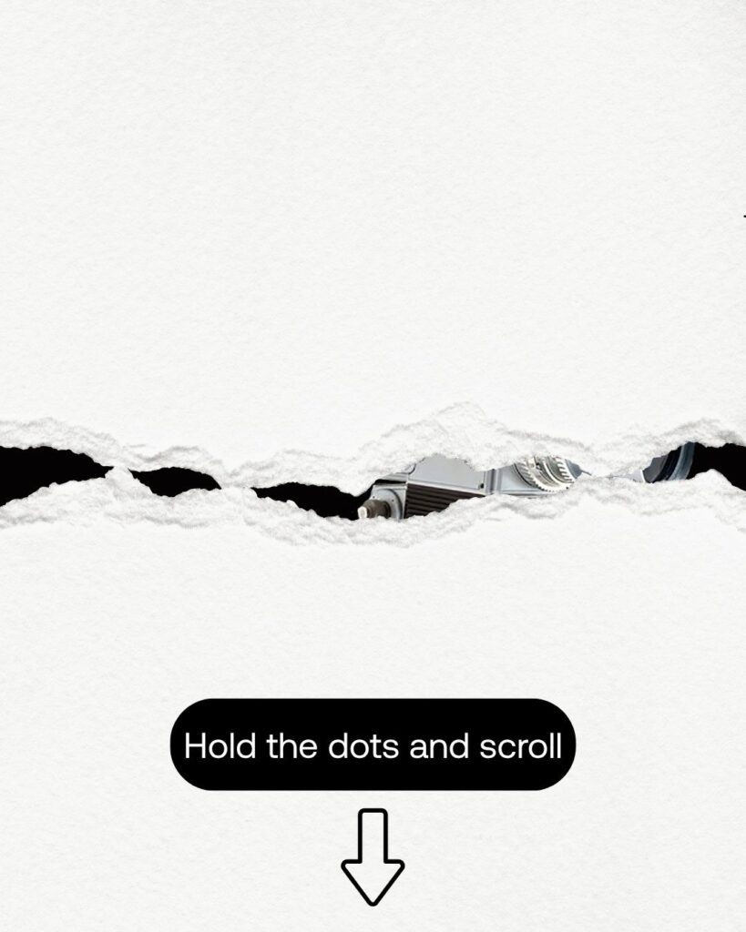 A torn white paper reveals a small part of a camera lens underneath. Below the tear, a black rounded rectangle contains the text "Hold the dots and scroll" with a downward-pointing arrow beneath it.