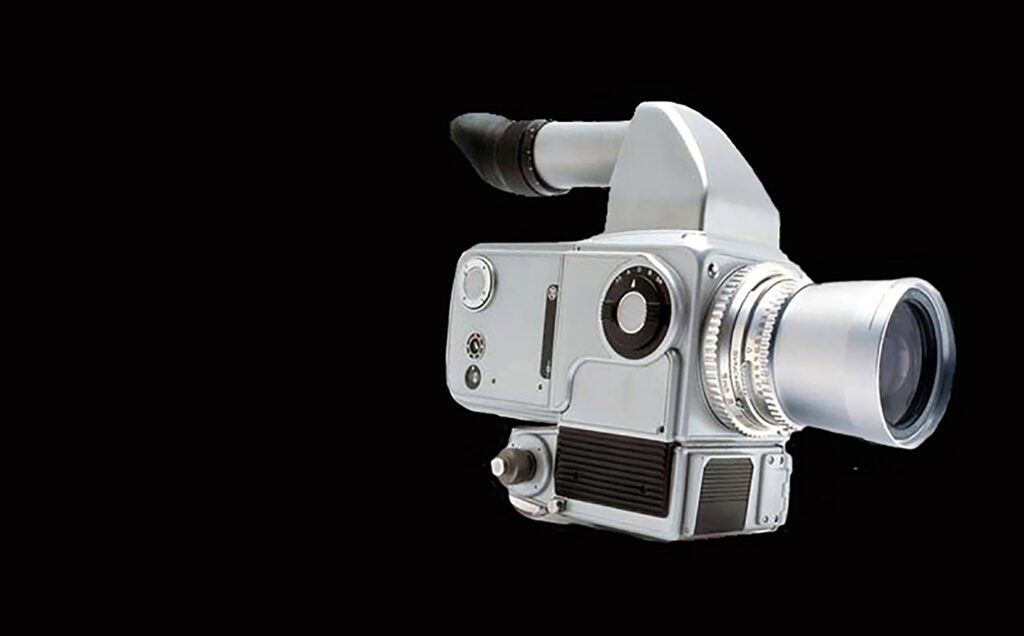 A vintage film camera with a large lens and viewfinder is positioned against a solid black background, highlighting its mechanical details and classic design.